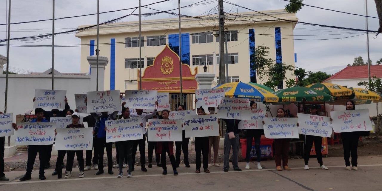 Workers with signs concerning freedom of association violations at Wing Star Shoes